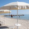 Spiaggia con lettini e ombrelloni bianchi.