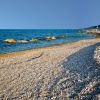 Spiaggia di ciottoli e mare con rocce.