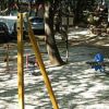 Parco giochi con altalene, scivolo e dondoli tra gli alberi.