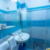 Un bagno moderno con doccia, lavabo, specchio ampio e piastrelle blu e bianche.
