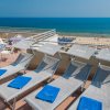 Terrazza con lettini e vista sul mare e spiaggia affollata.