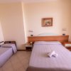 Camera da letto con letto matrimoniale e singolo, pareti chiare.