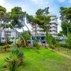 Un hotel circondato da un giardino verde e alberi.