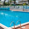 Piscina azzurra all'aperto con piastrelle rosse attorno.