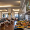 Sala da pranzo elegante con tavoli apparecchiati e buffet ricco di piatti colorati.