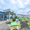 Terrazza esterna con tavoli colorati e vista sulla spiaggia.