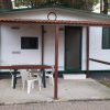 Bungalow bianco con portico e sedie.