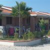 Un bungalow con tetti rossi, circondato da palme e biciclette.
