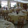 Sala da pranzo elegante con tavoli apparecchiati.