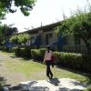 Persona cammina accanto a cottage con terrazze alberate.