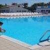 Piscina con un bagnino accucciato vicino al bordo.