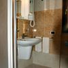 Bagno con lavabo, specchio, ripiani e asciugacapelli.