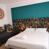 Camera da letto con testiera floreale e decorazioni murali.